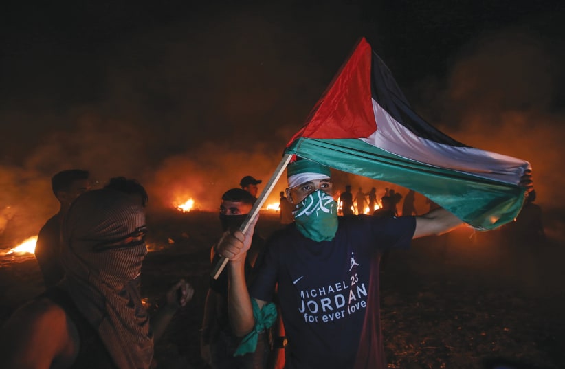  PALESTINIANS PROTEST near the border fence with Israel east of Gaza City. (photo credit: ATIA MOHAMMED/FLASH90)