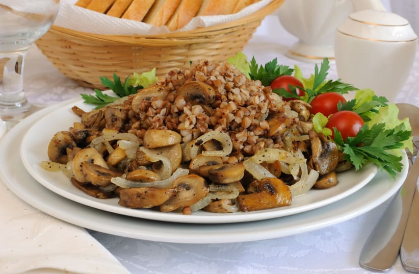 Buckwheat porridge with mushrooms and onions on the dining table (photo credit: INGIMAGE)