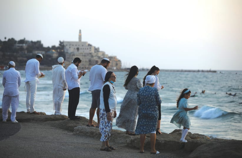  Residents of Tel Aviv perform the Tashlich ceremony, whereby they symbolically cast away their sins (photo credit: NIR ELIAS / REUTERS)