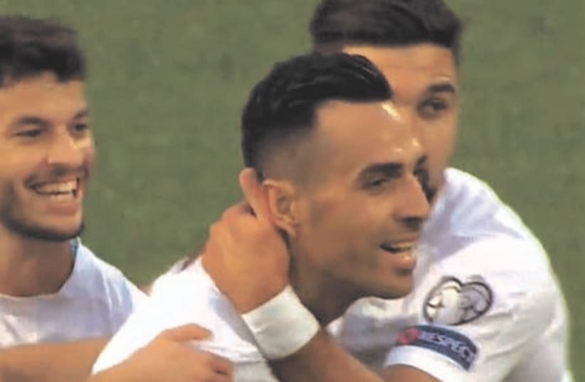  ISRAEL STRIKER Eran Zahavi (center) celebrates with his teammates after scoring the opening goal – his first of three on the night – for the blue-and-white in its 4-0 away victory at the Faroe Islands in Group F World Cup qualifying. (photo credit: Sport5)