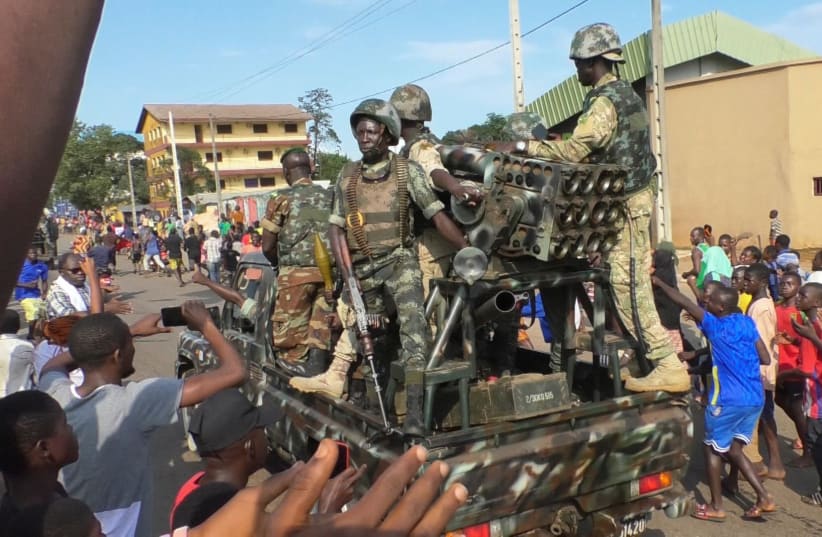 Residents cheer at army soldiers as they celebrate the uprising in Conakry, Guinea September 5, 2021. (photo credit: REUTERS/SOULEYMANE CAMARA)