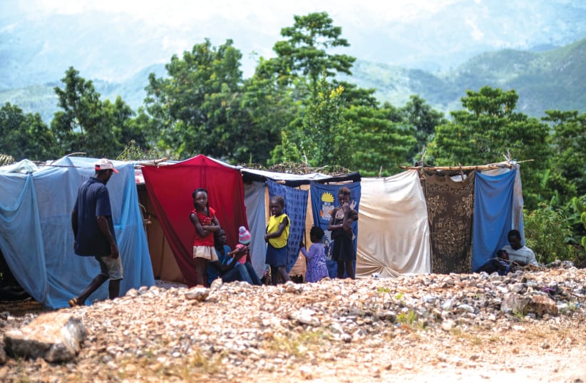 SURVIVORS OF a 7.2 magnitude earthquake on August 14 shelter at makeshift tents after the quake damaged or destroyed their houses in the Nan Konsey neighborhood of Pestel, Haiti (photo credit: Ricardo Arduengo/Reuters)