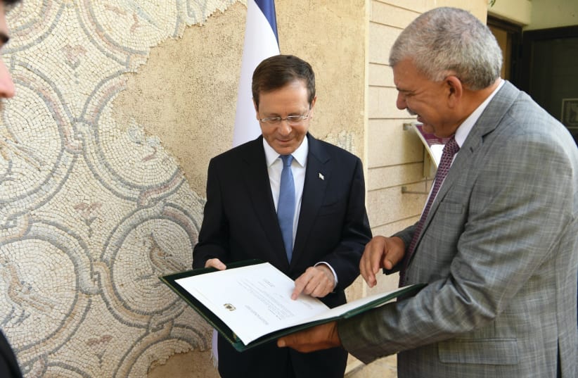  BDERRAHIM BEYYOUDH, Morocco’s chargé d’affaires, presents President Isaac Herzog a signed copy of King Mohammed VI’s letter from last month. (photo credit: AMOS BEN-GERSHOM/GPO)