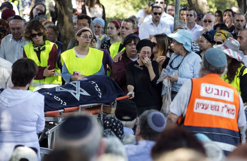  MOURNING AT the funeral  following a terror attack near  Tekoa, 2014. Sherri Mandell’s  son, Koby, was killed in a similar  earlier attack.  (photo credit: BAZ RATNER/REUTERS)