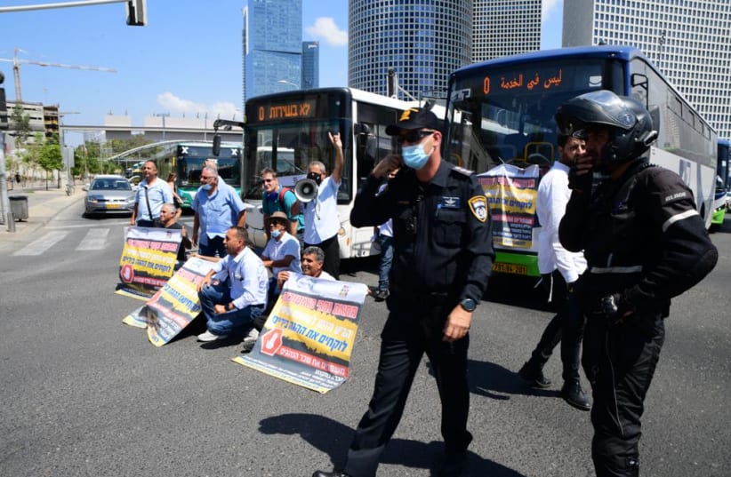  Bus drivers protest in front of parked buses and Israel Police officers on September 12, 2021. (photo credit: AVSHALOM SASSONI)