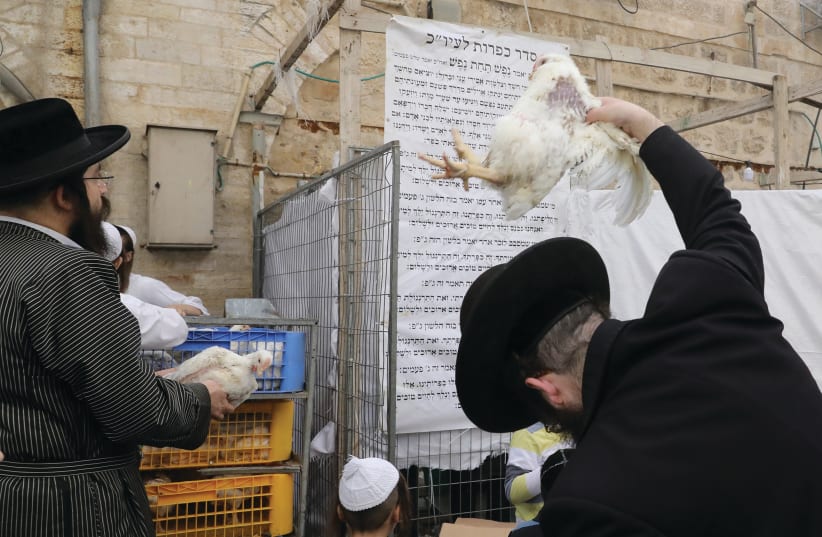  A man performs the Kapparot ceremony in Jerusalem. (photo credit: MARC ISRAEL SELLEM)