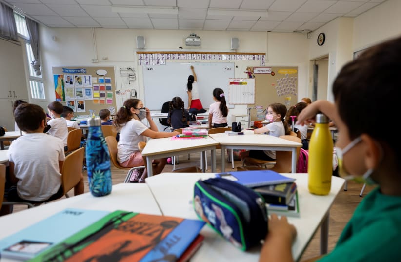  Children wearing face masks attend a class as students return to school after the summer break, less than a month into a coronavirus disease (COVID-19) vaccine booster drive, at Arazim Elementary School in Tel Aviv, Israel September 1, 2021 (photo credit: REUTERS/AMIR COHEN)