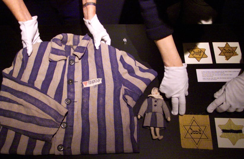  CURATORS LAY out a concentration camp uniform from 1944 Bergen-Belsen, a child’s doll and Jewish stars at the Powerhouse Museum in Sydney, Australia. (photo credit: REUTERS)