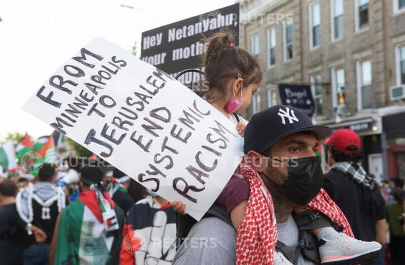  A placard at a pro-Palestinian rally in New York in May demonstrates the Left’s understanding that racism in the US is comparable to what Palestinians contend with in Israel. (photo credit: REUTERS)