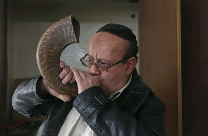  Zabulon Simantov, an Afghan Jew, blows the traditional shofar, or ram's horn, at a synagogue in Kabul (photo credit: REUTERS/OMAR SOBHANI)