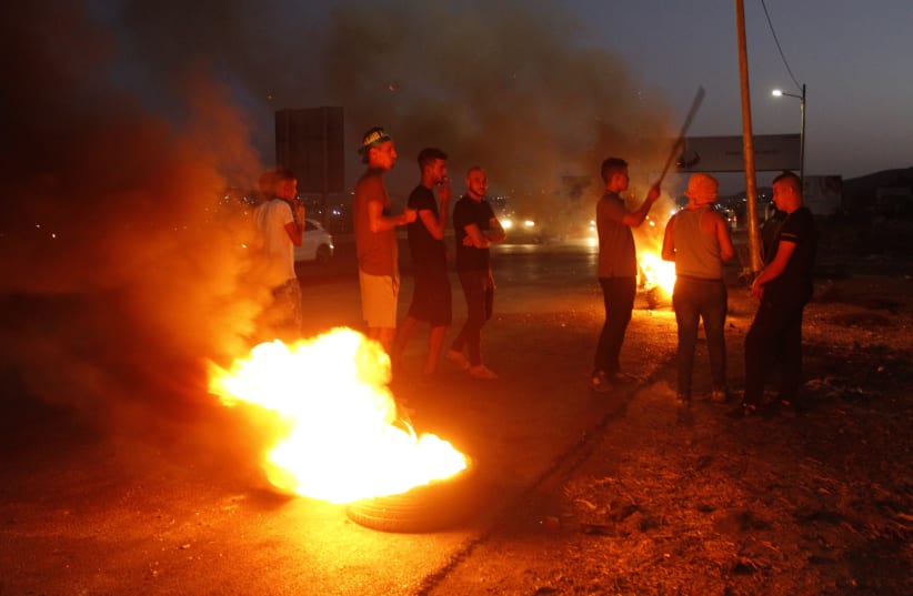 Palestinians demonstrate at the Israeli Hawara checkpoint near the city of Nablus and clash with Israeli security forces  on September 13, 2021.  (photo credit: NASSER ISHTAYEH/FLASH90)
