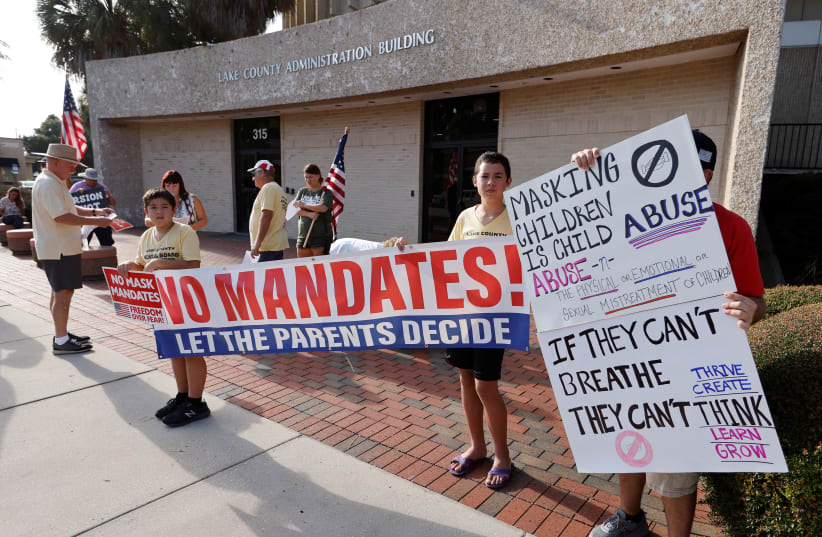  Residents demonstrate before the Lake County School Board started an emergency meeting to discuss mask mandates to prevent the spread of coronavirus disease (COVID-19) in Tavares, Florida, US, September 2, 2021. (photo credit: REUTERS/JOE SKIPPER)