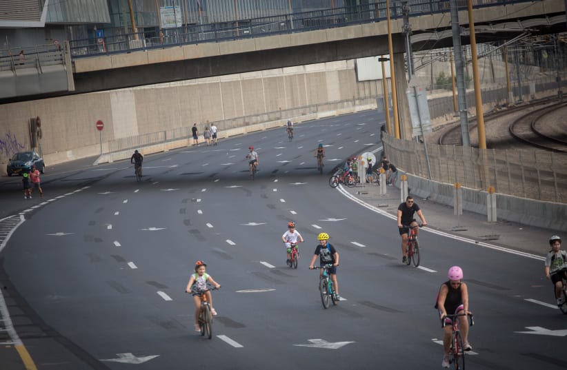 Israelis ride their bicycles along the empty Ayalon highway in Tel Aviv, on Yom Kippur, the Day of Atonement, and the holiest of Jewish holidays. Israel came to a standstill for 25-hours during the high holiday of Yom Kippur when observant Jews fast and Israelis are prohibited from driving.  (photo credit: MIRIAM ALSTER/FLASH90)