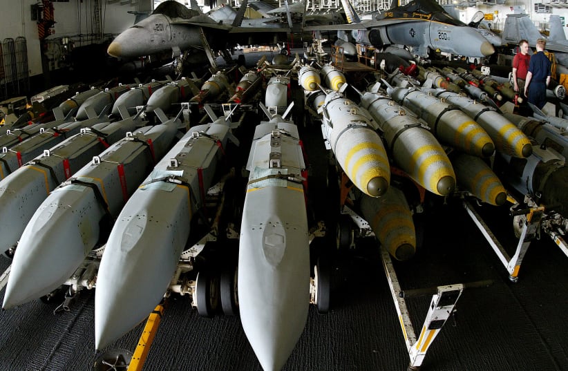  Aviation ordonancemen stand next to JSOW (Joint Standoff Weapon) (left) and JDAM satellite guided bombs (right) aboard the USS Kitty Hawk aircraft carrier in the northern Gulf April 9, 2003 (photo credit: YVES HERMAN/REUTERS)