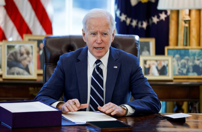  US President Joe Biden signs the American Rescue Plan, a package of economic relief measures to respond to the impact of the coronavirus disease (COVID-19) pandemic, inside the Oval Office at the White House in Washington, US, March 11, 2021.  (photo credit: REUTERS/TOM BRENNER)