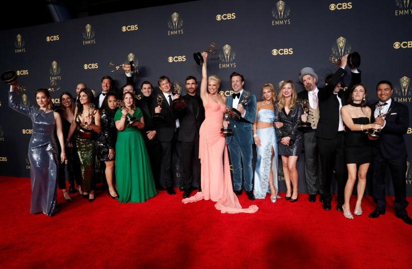  The cast and crew members of comedy series "Ted Lasso" pose for a picture with their awards at the 73rd Primetime Emmy Awards in Los Angeles, US, September 19, 2021 (photo credit: REUTERS/MARIO ANZUONI)
