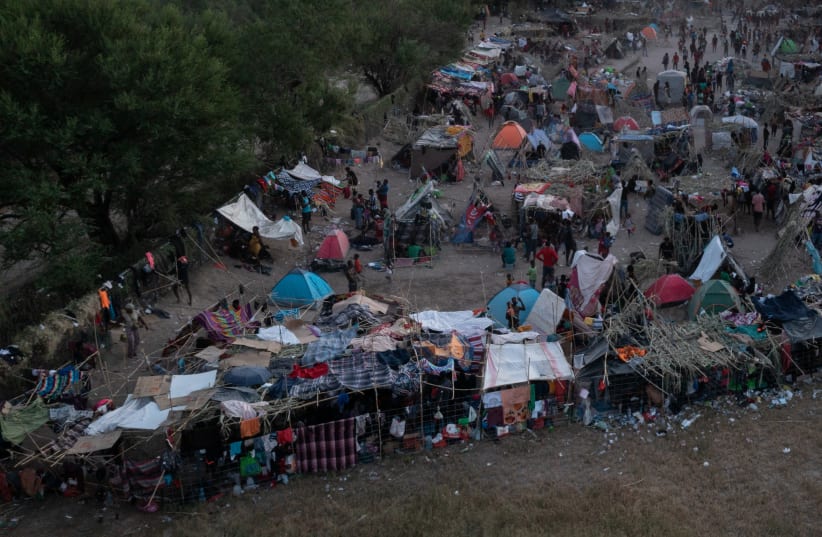  Migrants take shelter in makeshift camp while awaiting to be processed along the International Bridge in Del Rio, Texas, U.S. September 20, 2021. (photo credit: REUTERS/ADREES LATIF)