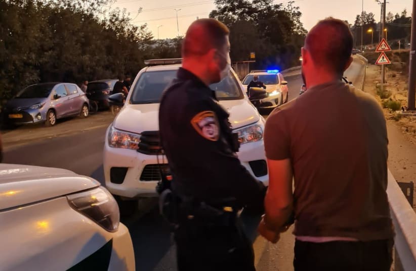 A policeman arrests a man accused of being involved in a car ramming in Nahariya on September 21, 2021. (photo credit: POLICE SPOKESPERSON'S UNIT)