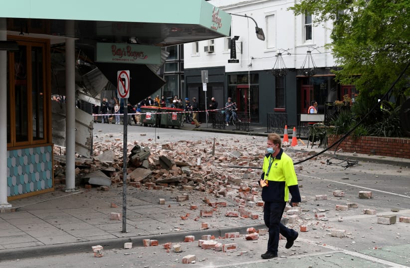  A person walks past damage to the exterior of a restaurant following an earthquake in the Windsor suburb of Melbourne, Australia, September 22, 2021.  (photo credit: AAP IMAGE/JAMES ROSS/VIA REUTERS)