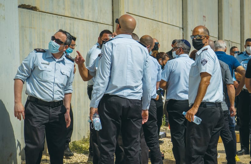  THIRD WORLD and First World Israel: Police officers and prison guards mill around the scene of the prison escape at Gilboa Prison this month. (photo credit: FLASH 90)