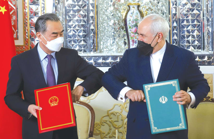  IRAN’S FOREIGN MINISTER Mohammad Javad Zarif and China’s Foreign Minister Wang Yi bump elbows during the signing ceremony of a 25-year cooperation agreement, in Tehran, in March. (photo credit: MAJID ASGARIPOUR/WANA/REUTERS)