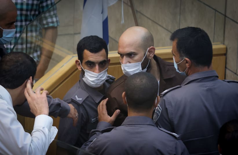  Ayham Kamamji, one of the six prisoners who escaped out of Israel's high security Gilboa prison, a few weeks ago is surrounded by Israeli police officers at the Magistrates court in the northern Israeli city of Nazareth, September 19, 2021. (photo credit: DAVID COHEN/FLASH 90)