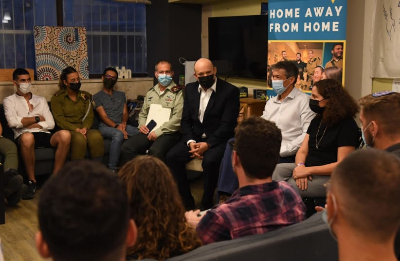  Prime Minister Naftali Bennett meets with lone soldiers at a sukkah in Jerusalem (photo credit: CHAIM TZACH/GPO)