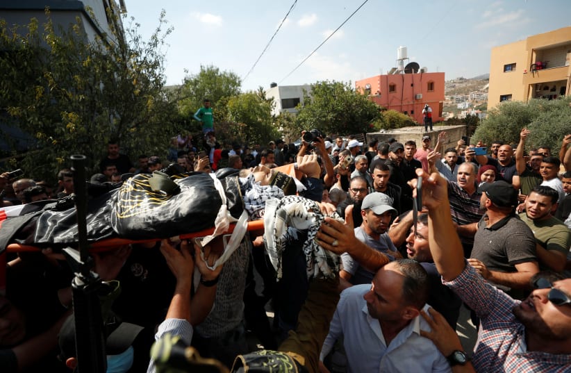  Palestinians carry the body of Islamic Jihad gunman Alaa Zyoud who was killed by Israeli forces during exchange of fire in a raid, during his funeral near Jenin, September 30, 2021.  (photo credit: REUTERS/MOHAMAD TOROKMAN)