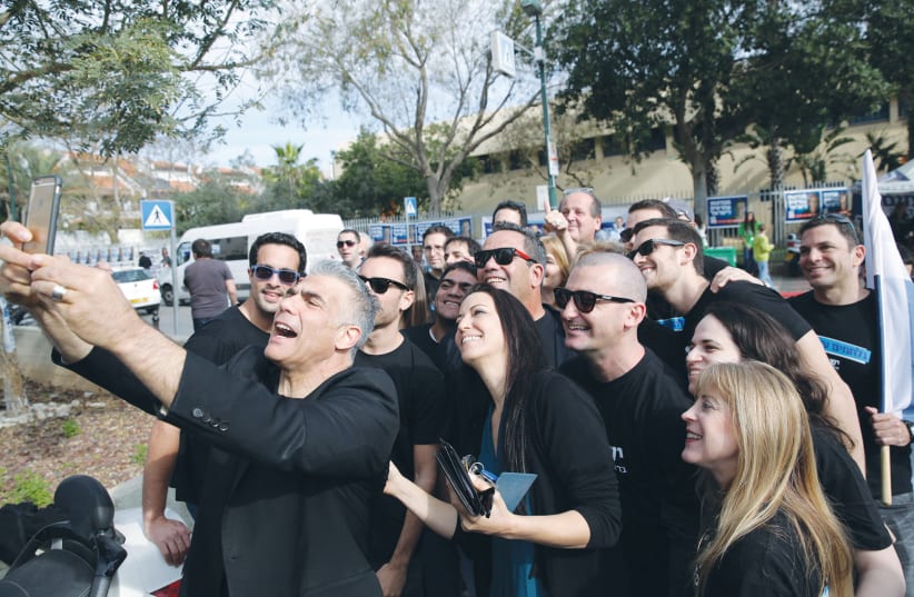  YESH ATID leader Yair Lapid and his wife, Lihi, take a selfie with supporters in Tel Aviv in 2015.  (photo credit: REUTERS)