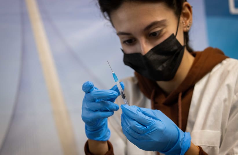  Health worker prepares a Covid-19 vaccine at a temporary Clalit health care center in Jerusalem, September 30, 2021. (photo credit: YONATAN SINDEL/FLASH90)