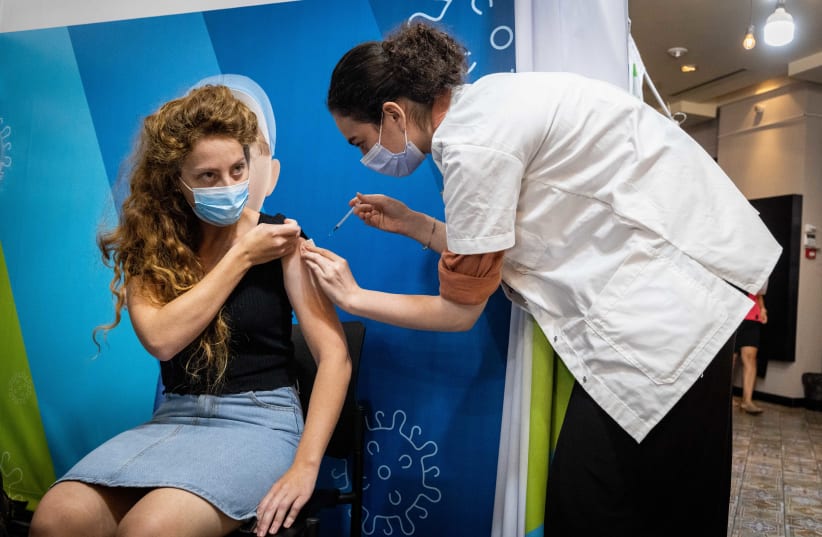  A woman receives a dose of the COVID-19 vaccine at a temporary Clalit health care center in Jerusalem, September 30, 2021.  (photo credit: YONATAN SINDEL/FLASH90)