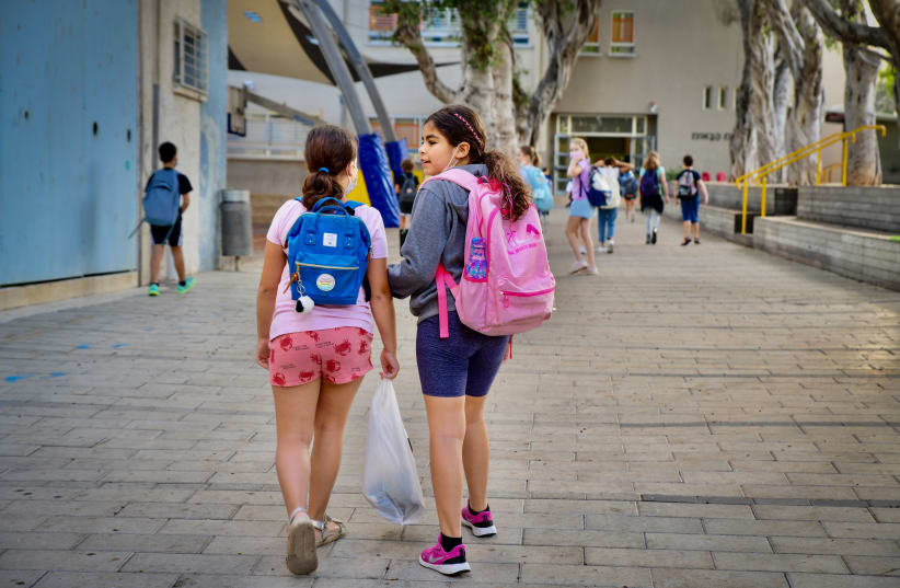  Young Israeli students arrive for their first day of school after the holidays, at Gabrieli school, in Tel Aviv.  September 30, 2021.  (photo credit: AVSHALOM SASSONI/FLASH90)