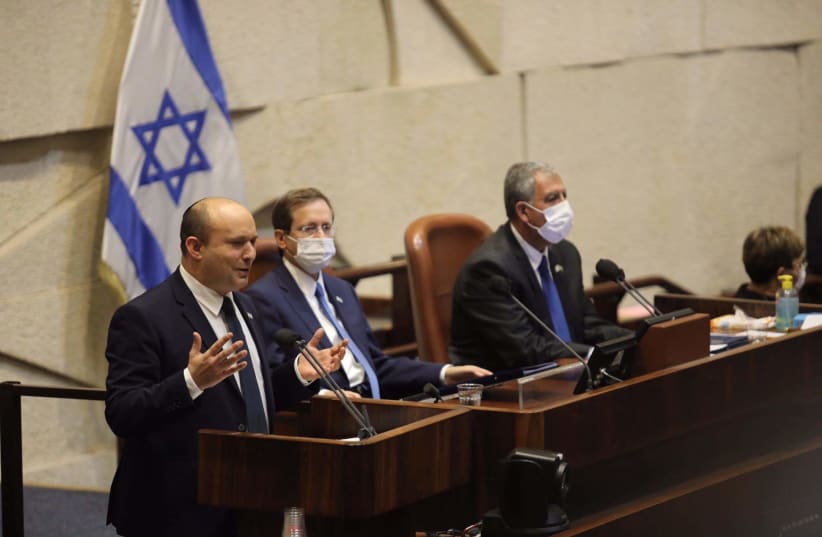   Prime Minister Naftali Bennett speaks at the Knesset plenum in the presence of President Isaac Herzog and Knesset Speaker Mickey Levy on October 4, 2021. (photo credit: MARC ISRAEL SELLEM)