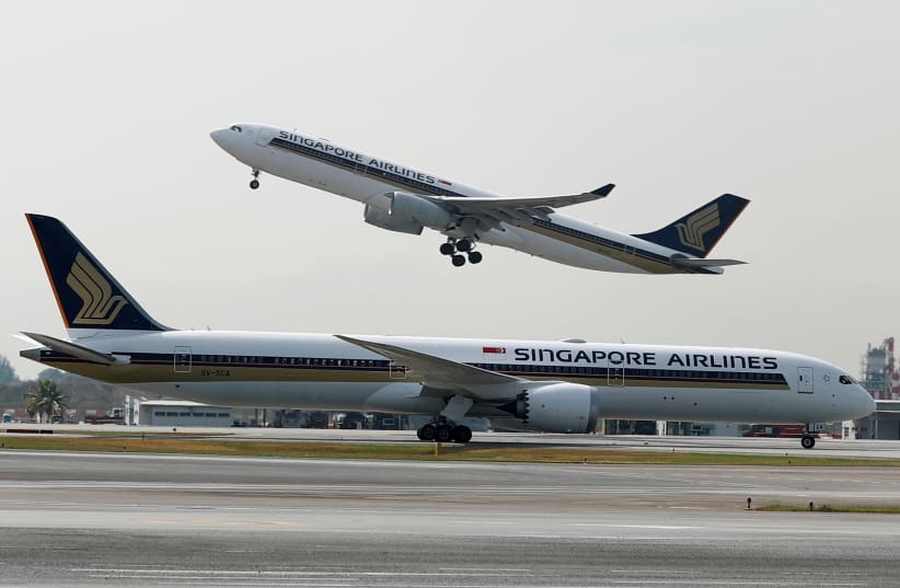  A Singapore Airlines Airbus A330-300 plane takes off behind a Boeing 787-10 Dreamliner at Changi Airport in Singapore March 28, 2018. (photo credit: REUTERS/EDGAR SU)