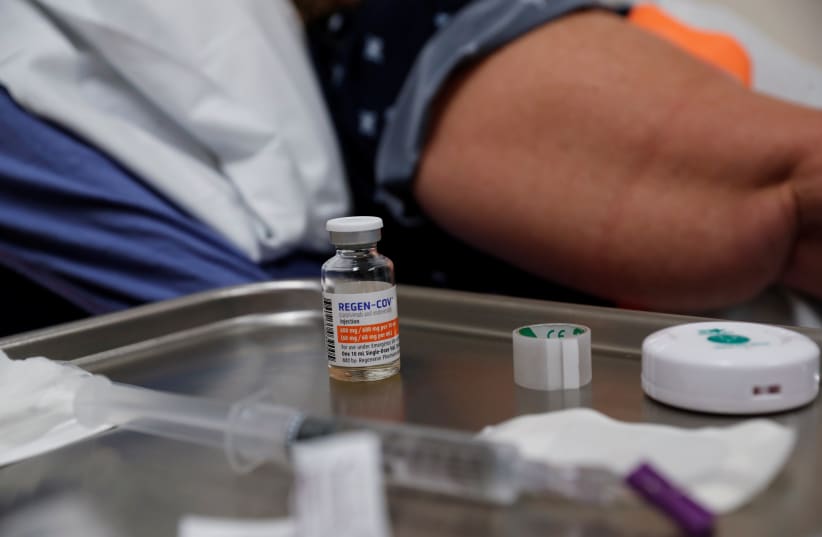 A vial of Regeneron monoclonal antibody sits on a medical table as registered nurse Jessica Krumwiede attempts to find a vein to administer it to Cathy Hardin, who was vaccinated prior to testing positive for the coronavirus disease (COVID-19), at the Sarasota Memorial Urgent Care Center in Sarasota (photo credit: REUTERS/SHANNON STAPLETON)
