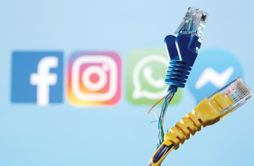  BROKEN ETHERNET CABLES are seen in front of Facebook, WhatsApp, Instagram and Messenger logos in an illustrative photo taken this week.  (photo credit: DADO RUVIC/REUTERS)