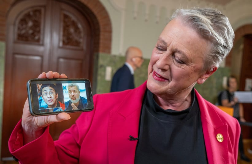  Chair of the Norwegian Nobel Peace Prize Committee Berit Reiss-Andersen shows on a mobile phone laureates of the 2021 Nobel Peace Prize, journalists Maria Ressa and Dmitry Muratov, in the Nobel Institute in Oslo, Norway (photo credit: NTB/Heiko Junge via REUTERS)