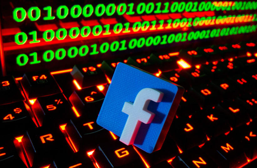  A 3D printed Facebook logo is pictured on a keyboard in front of binary code in this illustration taken September 24, 2021. (photo credit: REUTERS/DADO RUVIC/ILLUSTRATION)
