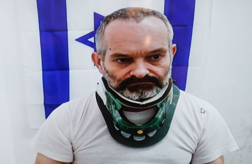  Guy Shapira, charged with the murder of his wife in Ma'ale Adumim, is seen on a screen via a video link during a court hearing at the Jerusalem Magistrate's Court, on October 7, 2021. (photo credit: OLIVIER FITOUSSI/FLASH90)