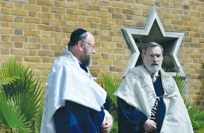  CHIEF RABBI Jonathan Sacks handing over the position to Rabbi Ephraim Mirvis at a ceremony in London in 2013. (photo credit: TOBY MELVILLE/REUTERS)