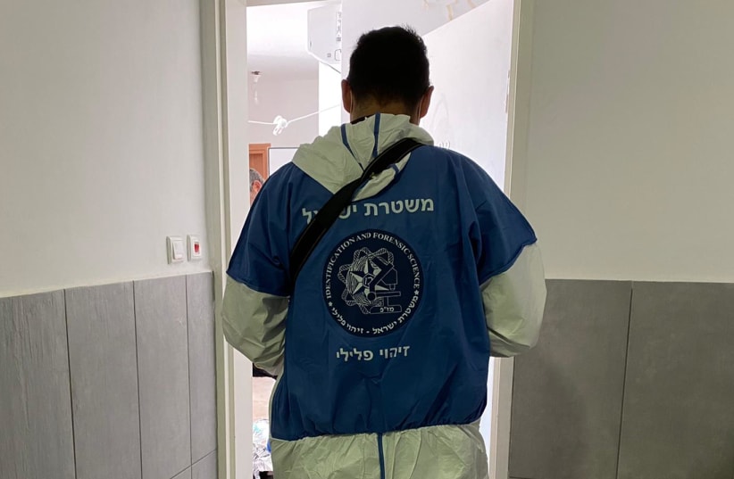  A member of the Israel Police Identification and Forensic Science department conducts an investigation, October 2021 (photo credit: ISRAEL POLICE SPOKESMAN)