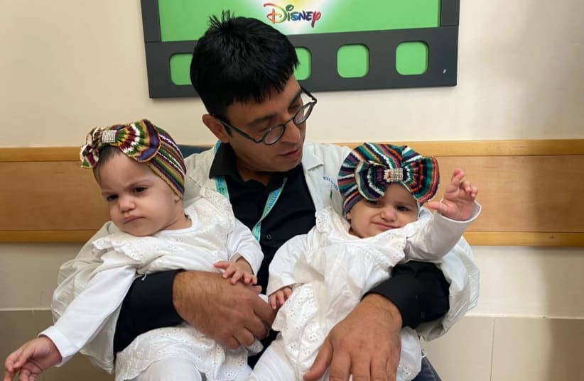  Dr. Mickey Gideon Director of Pediatric Neurosurgery at Soroka University Medical Center and one of the lead surgeons of the operation, with the twins. (photo credit: Courtesy)