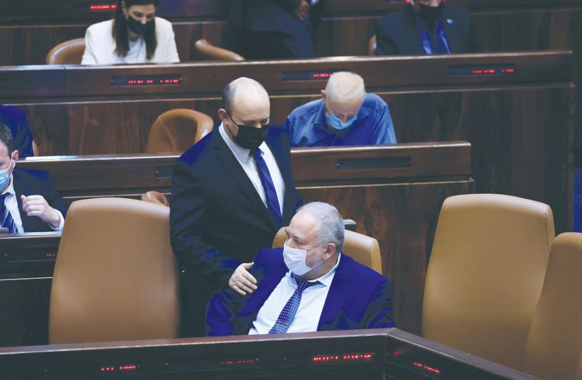 Prime Minister Naftali Bennett with Finance Minister Avigdor Liberman during a vote on the state budget in the Knesset last month. (photo credit: OLIVIER FITOUSSI/FLASH90)