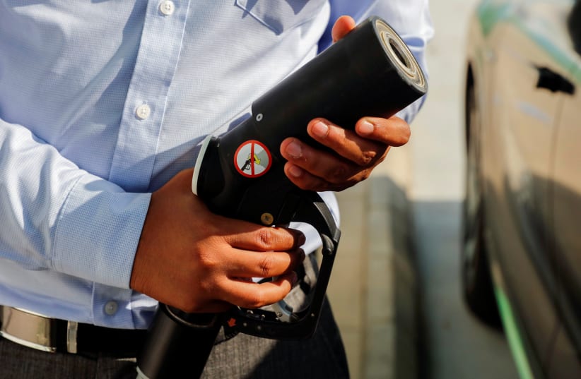  A man refuels a car at Hydrogen refuelling station during Saudi Aramco's media trip to demonstrate Hydrogen automotive technology at Techno Valley Science Park in Dhahran, Saudi Arabia, June 27, 2021. (photo credit: REUTERS/HAJER ABDULMOHSIN)