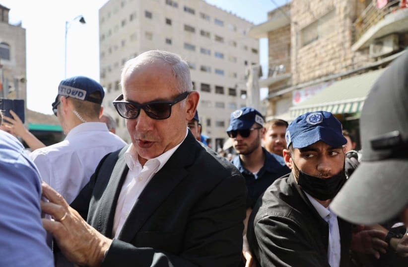 Opposition leader Benjamin Netanyahu is seen pushing his way through Jerusalem's Mahane Yehuda market, on October 26, 2021. (photo credit: MARC ISRAEL SELLEM/THE JERUSALEM POST)
