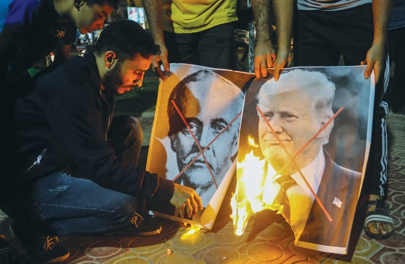PALESTINIANS IN RAFAH burn posters of former US president Donald Trump and Arthur James Balfour during a protest last year on the anniversary of the Balfour Declaration. (photo credit: ABED RAHIM KHATIB/FLASH90)