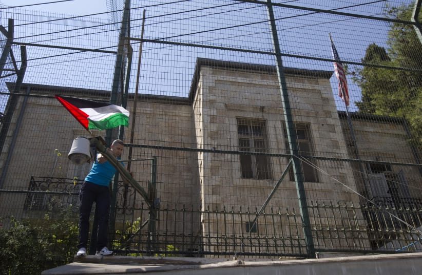  A man places a Palestinian flag on a fence surrounding the U.S. consulate during a rally in support of Palestinian President Mahmoud Abbas' bid for statehood recognition in the United Nations, in Arab East Jerusalem September 21, 2011 (photo credit: REUTERS/Ronen Zvulun)