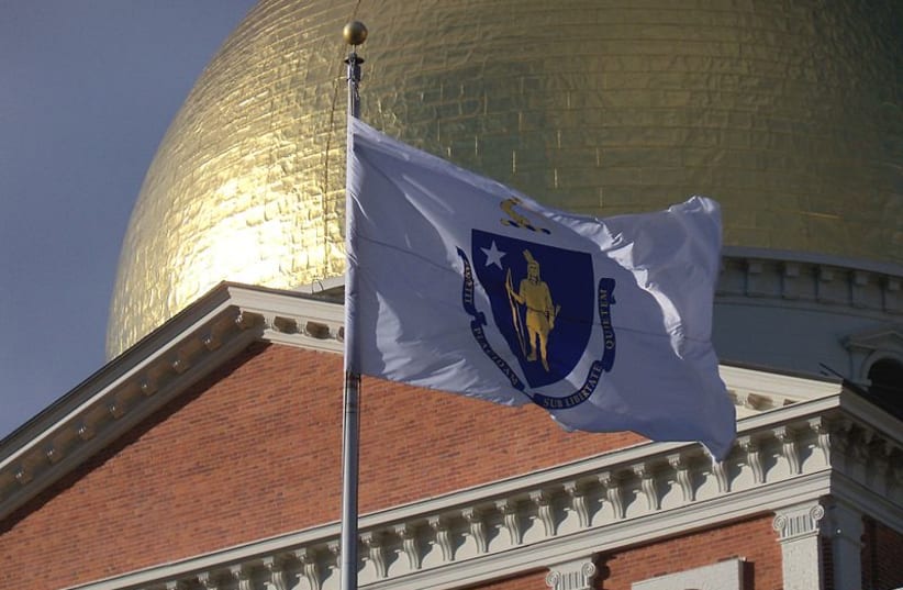 Massachusetts state flag in front of the gilded dome of the Massachusetts State House in Boston, Massachusetts, USA. (photo credit: Wikimedia Commons)