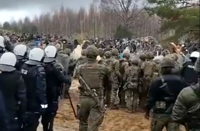 Polish police and border guard block hundreds of migrants who try to cross from the Belarus side of the border with Poland near Kuznica Bialostocka, Poland, in this video-grab released by the Polish Interior Ministry, November 8, 2021. (photo credit: MSWIA/HANDOUT VIA REUTERS)