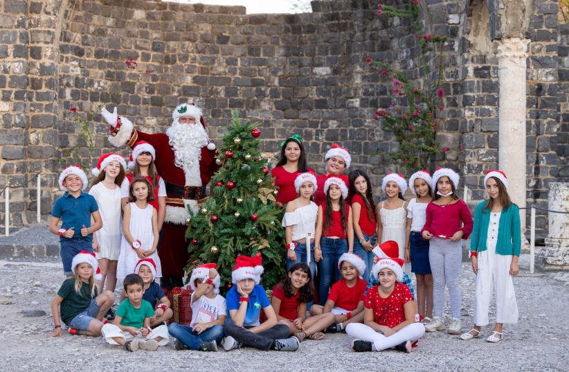  Santa Claus stands in the Kursi National Park with a Christmas tree and children for his annual Christmas greetings message. (photo credit: OMRI MESIKA, ROEE PERETZ)